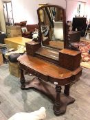 A Victorian mahogany dressing table, with hinged dome mirror above a hinged top recess, flanked by