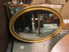 An Edwardian oval gilt framed wall mirror with beaded double border (76cm x 102cm)
