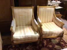 A pair of gilt wood Napoleon III style bergere chairs upholstered in striped fabric, on turned