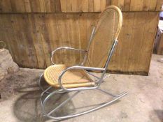 A late 20thc rocking chair, with cane back and seat, on tubular metal frame (115cm x 53cm x 106cm)
