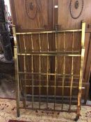 An Edwardian brass square section single bedstead comprising headboard and footboard on castors (one