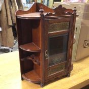 An early 20thc aesthetic style corner smoker's cabinet, with a bevelled glazed door enclosing an