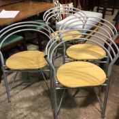 A set of four anodised metal beech seat stacking chairs, c.1980/90, with curved triple loop spar