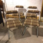 A set of four 1970s cantilever dining chairs with upholstered back rests and seats, on tubular metal