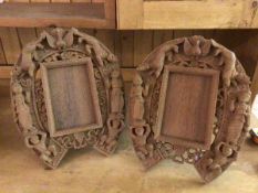 A pair of South East Asian carved wood photograph frames (each: 35cm x 29cm)