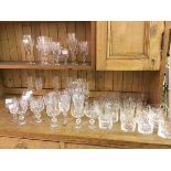 A collection of glassware including cut glass and crystal wine glasses, champagne flutes, brandy