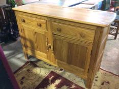 An Ercol light elm sideboard, the moulded rectangular top above a pair of frieze drawers and two