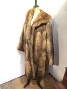 A fur coat with single fastening to front and pockets to sides (shoulders: 32cm x length: 100cm)