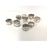 A group of nine silver napkin rings, various designs (combined: 248.85g)