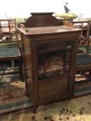 An Edwardian mahogany music cabinet, with ledge back (a/f), above a glazed and panelled door, the