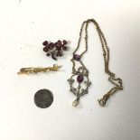 A 15ct gold bar brooch with two seed pearls, one missing (1.94g), a white metal brooch set red
