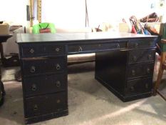 A late 19thc ebonised partner's desk with tooled leather top with frieze drawer and hinged writing