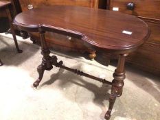 A Victorian mahogany kidney topped writing table, on turned supports with flower carved knees,