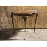 A 1930s/40s mahogany demi lune table, with cabriole legs ending in pad feet (73cm x 75cm x 38cm)