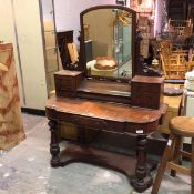 A Victorian mahogany dressing table, the domed mirror on carved supports with three short