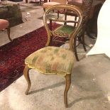 A Victorian balloon back walnut side chair, with a C scroll carved back rail above an upholstered
