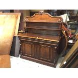 A Victorian mahogany sideboard, the superstructure with carved surmount and two shelves, on turned