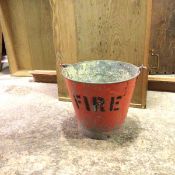 A vintage fire bucket with swing handle, painted red, with stencil to side (27cm x d.33cm)