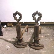A pair of late 19thc/early 20thc cast iron andirons, with a pierced foliate finial on a fluted