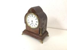 An Edwardian mantel clock of architectural form with roman numerals, on gilt metal bracket feet (