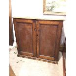 A late 19thc/early 20thc side cabinet, with moulded rectangular top above two panel doors, on plinth