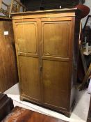 An Edwardian mahogany wardrobe, with moulded cornice above two panel doors, one door with mirror