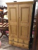 A Victorian stripped pine cabinet, the moulded cornice above two panel doors enclosing a shelved