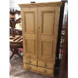 A Victorian stripped pine cabinet, the moulded cornice above two panel doors enclosing a shelved