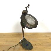 A reproduction aesthetic movement table lamp with a peacock finial above a shield shaped shade