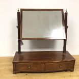 An Edwardian mahogany dressing table mirror, the rectangular glass on reeded supports, on a bow