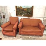 A 1920s two piece lounge suite comprising an upholstered easy chair and two seater drop end sofa, in