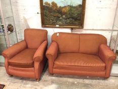 A 1920s two piece lounge suite comprising an upholstered easy chair and two seater drop end sofa, in