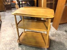 An Ercol light elm trolley, the rounded rectangular top with raised segmental gallery, lacking one