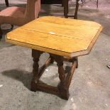 A 1920s/30s oak swivel top drop leaf occasional table, the square top with chamfered corners and