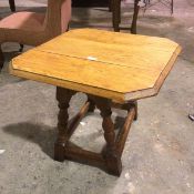 A 1920s/30s oak swivel top drop leaf occasional table, the square top with chamfered corners and