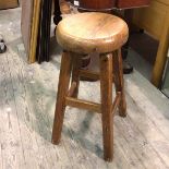 An elm stool with round seat on splay straight square supports united by stretchers (68cm x d.31cm)