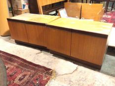 A pair of mid century teak low cabinets, with rectangular tops above a pair of fold out doors,