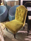 An Edwardian nursing chair, with arched top above a button back, in yellow/green upholstery, on
