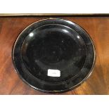 A Studio porcelain plate, probably Japanese, in black/brown glaze, the well spirally moulded with