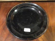 A Studio porcelain plate, probably Japanese, in black/brown glaze, the well spirally moulded with