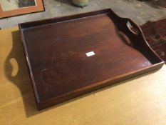 An early 20thc mahogany tray, with raised edge and pierced handles (9cm x 48cm x 54cm)