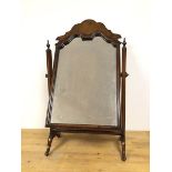 A 1930s/40s Queen Anne style walnut dressing table mirror on hinged supports with urn finials, on