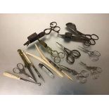 A collection of four various wick trimmers, miscellaneous nail scissors, glove stretchers, drawing