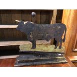 A folk art sculpture of Bull, of painted sheet metal on two tier painted base (52cm x 55cm x 15cm)