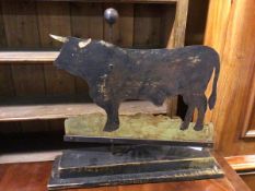 A folk art sculpture of Bull, of painted sheet metal on two tier painted base (52cm x 55cm x 15cm)