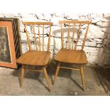 A pair of mid century beech and elm side chairs, with comb back, solid seat, on splay turned