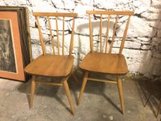 A pair of mid century beech and elm side chairs, with comb back, solid seat, on splay turned