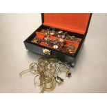 A jewellery box containing a collection of yellow metal and gilt metal chains, paste set floral