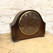 A 1950s Smiths mahogany mantel clock, the domed top above a circular glass cover, with roman