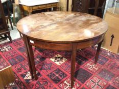 A 19thc mahogany dining table comprised of two D ends, lacking leaves, with plain frieze, on
